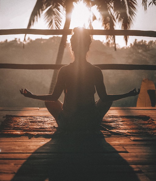 Mulher praticando meditação para bem-estar em um ambiente tranquilo.